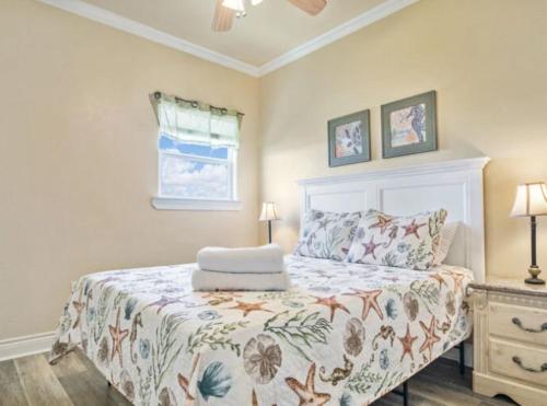 una camera da letto con un letto con copriletto floreale di Fancy Nancy 2 Min Walk to Beach, Lyft, Pet-friendly a Bolivar Peninsula