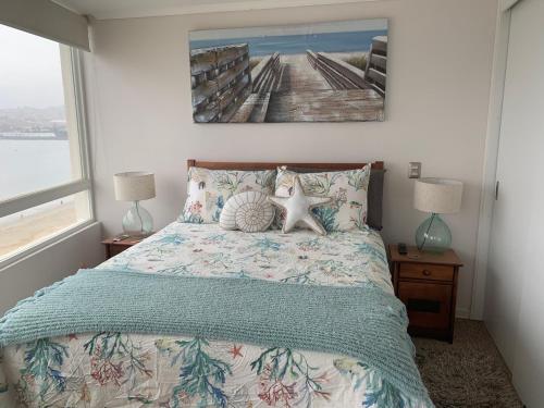 a bedroom with a bed and a picture on the wall at Departamento Playa Herradura in Coquimbo