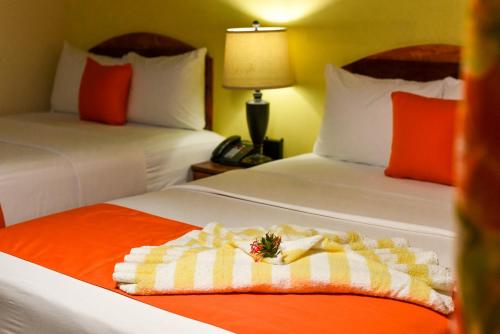 a hotel room with two beds with a towel at Melbourne Inn in Christ Church