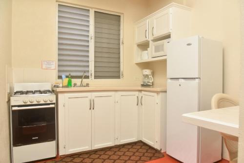 a kitchen with white cabinets and a white refrigerator at Melbourne Inn in Christ Church