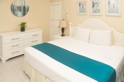 a bedroom with a white bed and a white dresser at Melbourne Inn in Christ Church