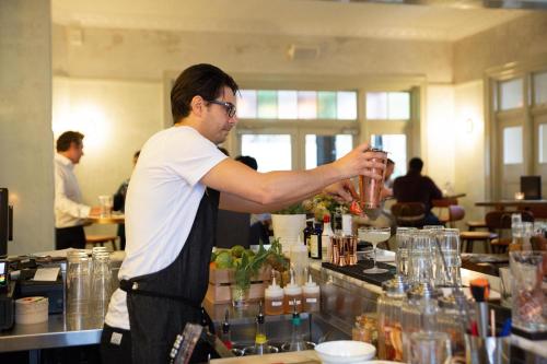 a man standing at a bar making a drink at Terminus Hotel Pyrmont in Sydney