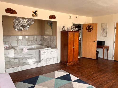 Una sala de estar con bañera y puerta de madera. en Ramada Downtown by Wyndham Anchorage, en Anchorage