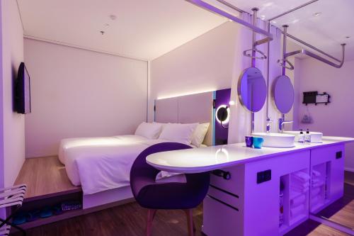 - une chambre avec un lit, un lavabo et un miroir dans l'établissement SOJO Hotel Ga Hanoi, à Hanoï