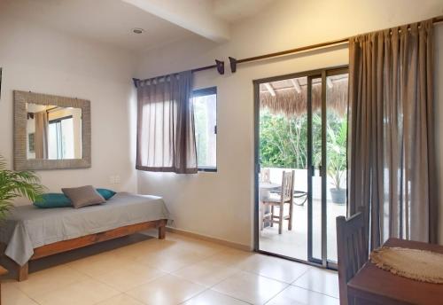 a bedroom with a bed and a sliding glass door at Buena onda residence in Tulum