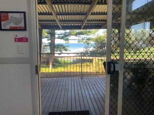 a door to a porch with a view of the ocean at NRMA Toowoon Bay Holiday Park in The Entrance