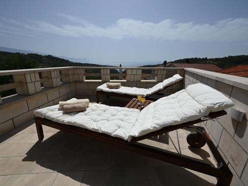 a bed on the roof of a balcony at House Palma in Selca
