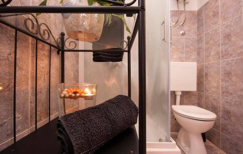 ein kleines Bad mit einem WC und einer Kerze in der Unterkunft Apartments Tresan in Tribunj