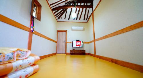 an empty room with a room with a tv in it at Jeonju Hanok Village Beautiful Garden House in Jeonju