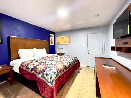 a hotel room with a bed and a tv at Golden Inn in Seagoville