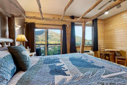 a bedroom with a bed with a view of a mountain at Gateway Inn in Grand Lake