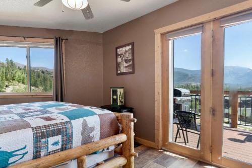 a bedroom with a bed and a balcony with mountains at Gateway Inn in Grand Lake