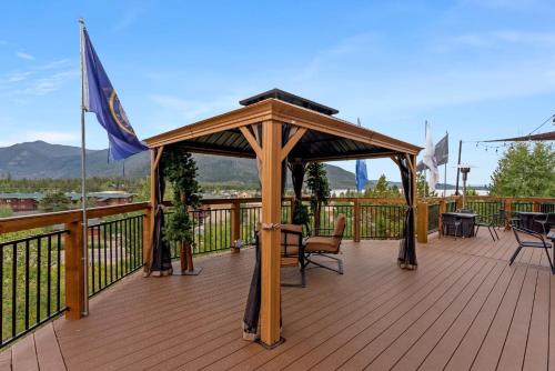 a wooden gazebo on a deck with tables and chairs at Gateway Inn in Grand Lake