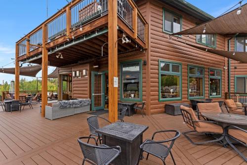 a house with a deck with tables and chairs at Gateway Inn in Grand Lake