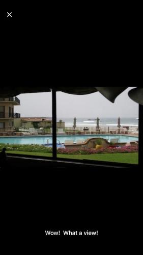 een raam met uitzicht op een zwembad bij Oceana Rosarito Condo Beach frontPrivately Owned downtown best views in Rosarito