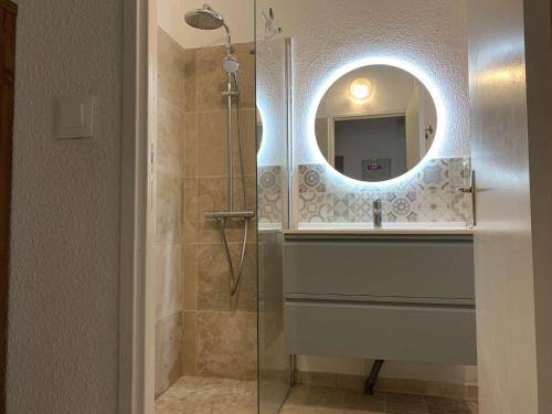 La salle de bains est pourvue d'une douche et d'un lavabo avec un miroir. dans l'établissement Maison soignée avec grand jardin et terrasse - Le Lavandou - FR-1-308-159, au Lavandou