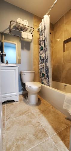 a bathroom with a toilet and a sink and a tub at Golden Inn in Seagoville