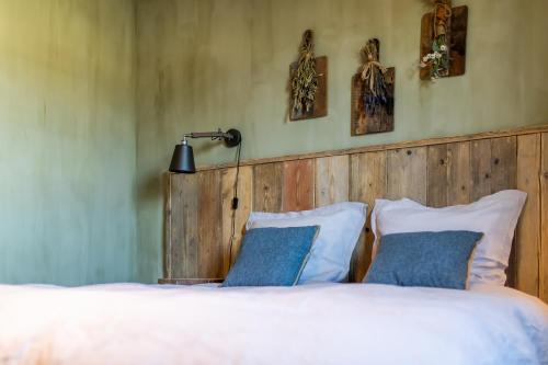 a bedroom with a bed with a wooden headboard and pillows at guesthouse Kamiele bij Lavendine Pure in Genk