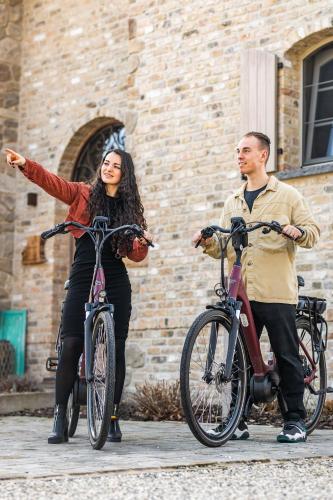 a man and a woman standing next to their bikes at guesthouse Kamiele bij Lavendine Pure in Genk