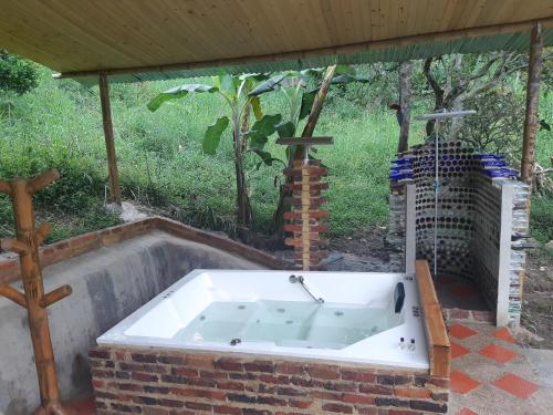 a bath tub sitting under a pavilion with a cross at Hospedaje Rural El Rancho de Amelia y Juancho in Silvania