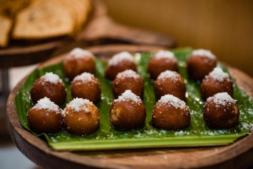 a plate of donuts with sugar on top of them at La-Paz Gardens Beacon Hotel - Vasco da Gama Goa in Vasco Da Gama