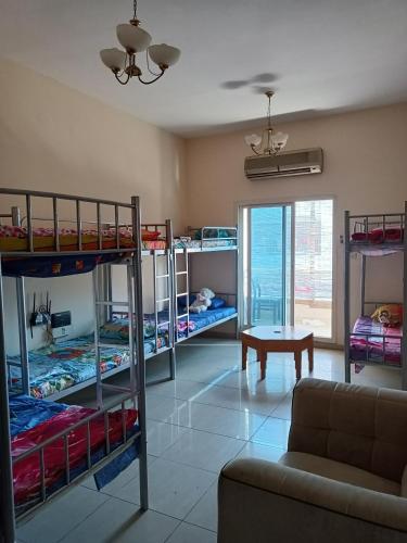 a living room with bunk beds and a couch at Suzy Hostel for boys in Dubai