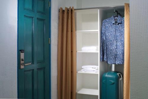 a blue suitcase in a closet next to a door at 1001 Nights Boutique Inn in Cagayan de Oro