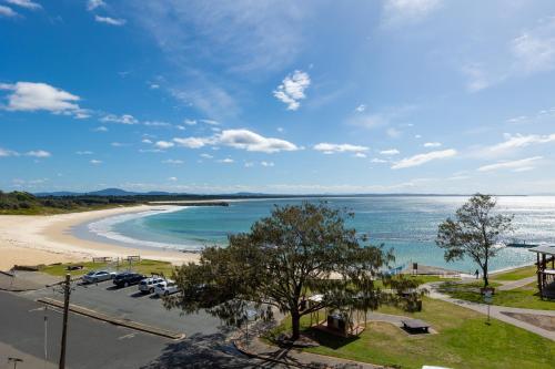 a view of a beach with cars parked on it at Beachpoint, Unit 101, 28 North Street in Forster