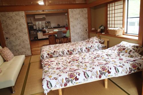 1 dormitorio con 1 cama con manta de flores en ワンコと泊まるジャスミンクリーク en Toyooka