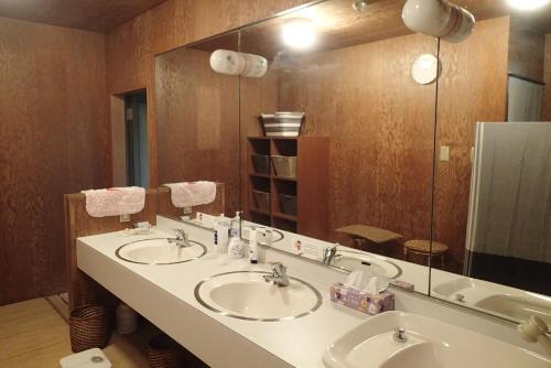 a bathroom with two sinks and a large mirror at ワンコと泊まるジャスミンクリーク in Toyooka