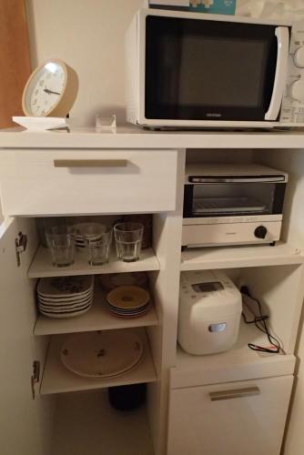a microwave oven sitting on top of a white cabinet at ワンコと泊まるジャスミンクリーク in Toyooka