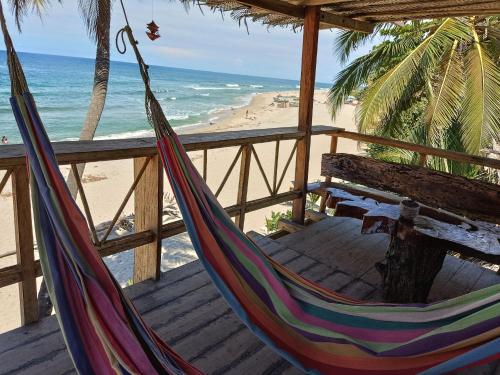 a hammock and a bench on a beach at Bob Marley Beach in Guachaca