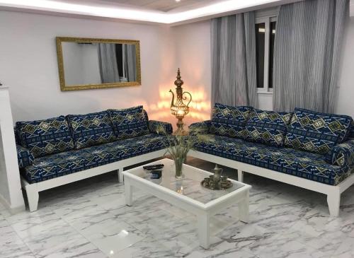 a living room with two couches and a table at Écrin in Sousse