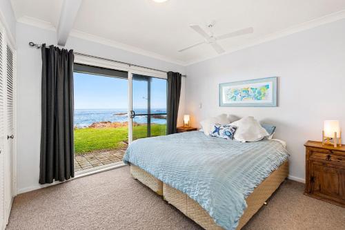 a bedroom with a bed and a view of the ocean at Birubi Lane 4 Anna Bay in Anna Bay