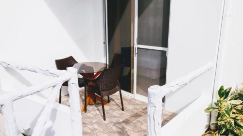 a glass table and chairs on a balcony at Meili Beach Resort in Alcoy