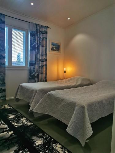 two beds in a bedroom with a window at Majoitus Valkea in Nunnanen