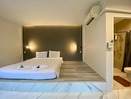 a bedroom with a large white bed and a bathroom at The dream garden in Ao Nang Beach