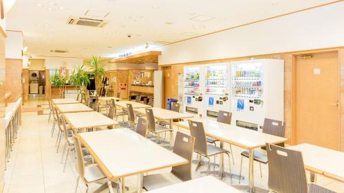 a dining room with tables and chairs in a restaurant at Toyoko Inn Hiroshima-eki Shinkansen-guchi 1 in Hiroshima