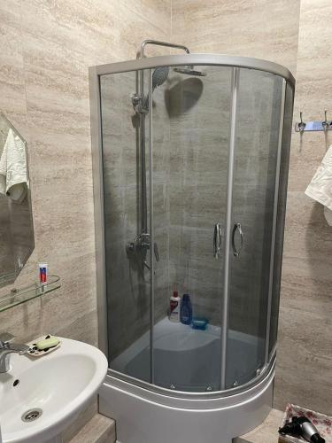 eine Dusche mit Glastür neben einem Waschbecken in der Unterkunft Raduga Issyk kul - Радуга Иссык куль in Chon-Sary-Oy
