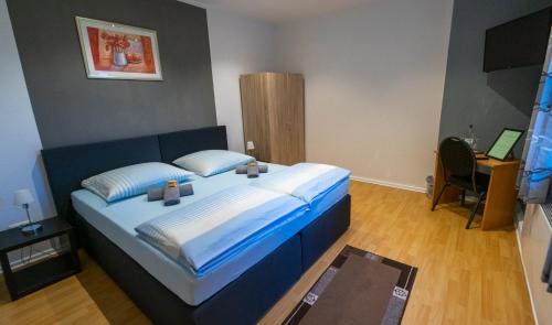 a bedroom with a large blue bed in a room at Hotel am Hafen in Braunschweig
