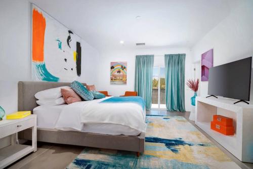 um quarto com uma cama e uma televisão de ecrã plano em Modern Desert Oasis – Pool, Spa and Mountain Views em Desert Hot Springs