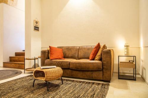 a living room with a brown couch with orange pillows at ELLEMENTS - Luxury Rooms in Brindisi