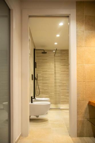 a bathroom with a tub and a sink and a toilet at ELLEMENTS - Luxury Rooms in Brindisi