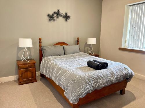 a bedroom with a large bed with two lamps at Peaches in Kingscote