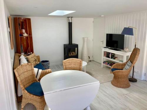 a living room with a table and chairs and a fireplace at Beachhouse Stranddistel 100m from the beach in Noordwijk aan Zee