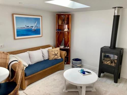 a living room with a couch and a wood stove at Have a nice stay! - Beachhouse Stranddistel 100m from the beach in Noordwijk aan Zee