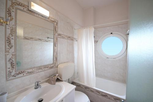 a bathroom with a toilet and a sink and a mirror at Scala Hotel-Apartments in Agia Pelagia