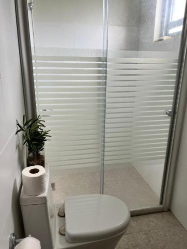 a bathroom with a toilet and a glass shower at D ARC Leisure Home By The Sea in Panglao