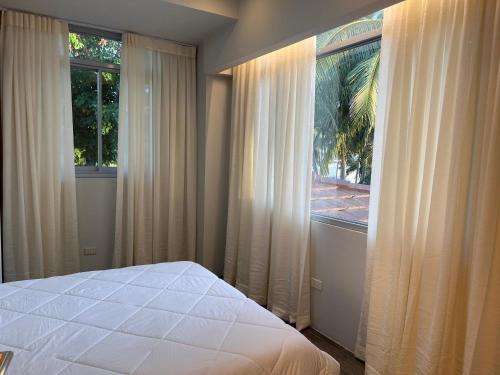 a bedroom with a bed and a large window at D ARC Leisure Home By The Sea in Panglao