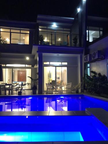 a house with a swimming pool at night at D ARC Leisure Home By The Sea in Panglao